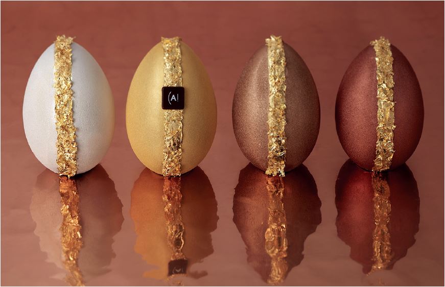 Quatre œufs aux couleurs de fête : Or, Argent, Cuivre et Bronze, qui découvrent sous une enveloppe scintillante des saveurs de chocolat noir grand cru du Brésil, chocolat au lait, lait et noisette.