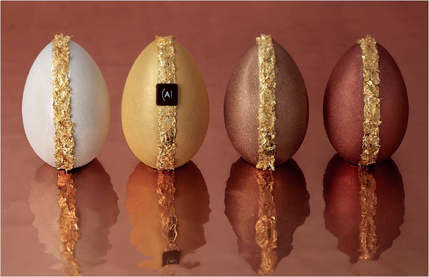 Quatre œufs aux couleurs de fête : Or, Argent, Cuivre et Bronze, qui découvrent sous une enveloppe scintillante des saveurs de chocolat noir grand cru du Brésil, chocolat au lait, lait et noisette. Quatre œufs aux couleurs de fête : Or, Argent, Cuivre et Bronze, qui découvrent sous une enveloppe scintillante des saveurs de chocolat noir grand cru du Brésil, chocolat au lait, lait et noisette.