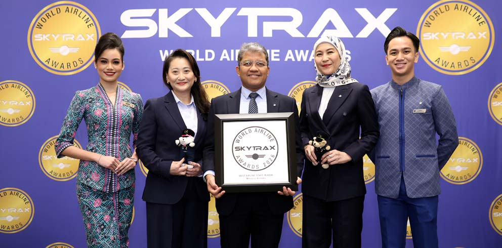 Au centre, le capitaine Nasaruddin A. Bakar, PDG du groupe MAG, à gauche Ong Min Hui, Directrice de la transformation et de l'expérience client, à droite Khairunnisak Dzun Nurin, Responsable de la communication, entourés par le personnel de cabine de Malaysia Airlines lors des Skytrax World Airline Awards 2026 - © Malaysia Airlines